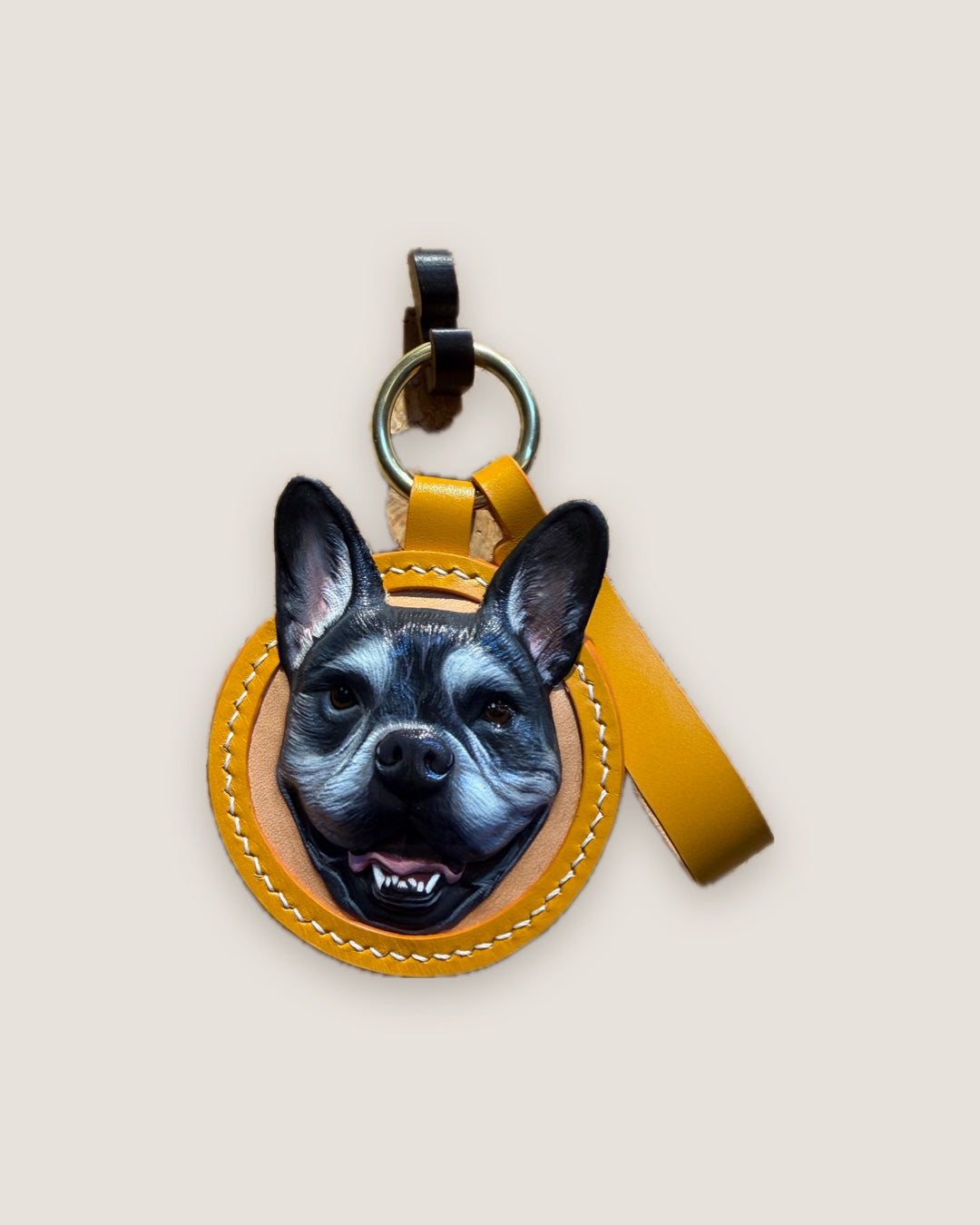Round keychain with a hand-painted French bulldog in yellow leather