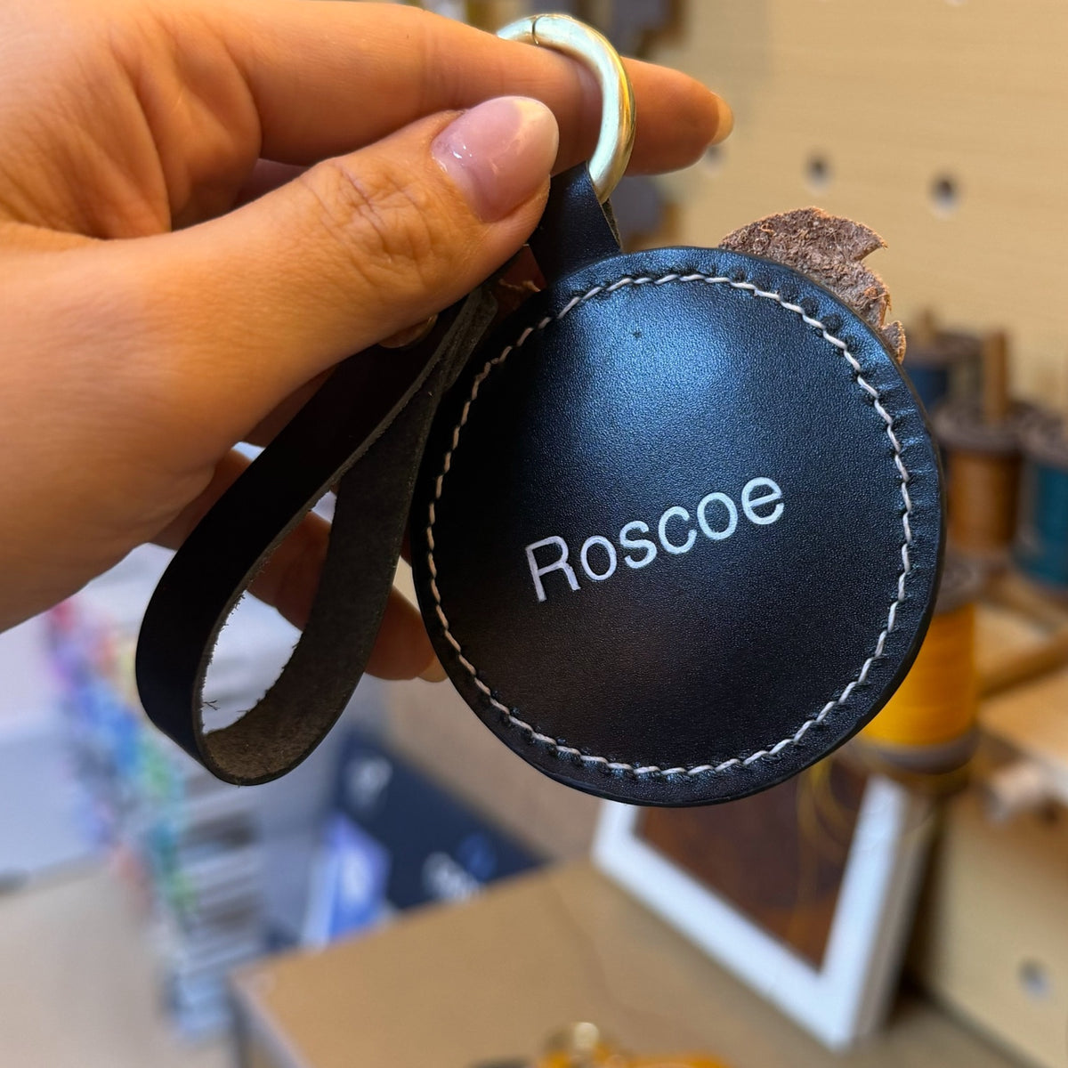Back of a keychain engraved with the name Roscoe