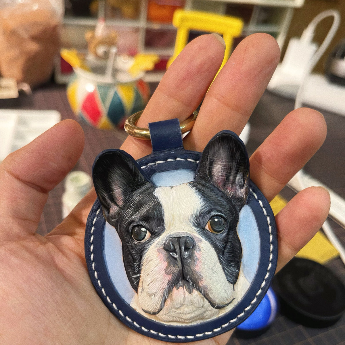Round keychain held in a palm to show its size